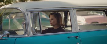 Movie still from “Monstrous” (2022), directed by Chris Sivertson – A woman sitting in the driver's seat of a van; Medium shot, High angle