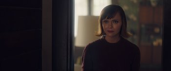 Movie still from “Monstrous” (2022), directed by Chris Sivertson – A woman standing in front of a mirror in a room; Close Up shot, Over the shoulder angle