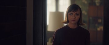 Movie still from “Monstrous” (2022), directed by Chris Sivertson – A woman standing in front of a mirror in a room; Close Up shot, Over the shoulder angle