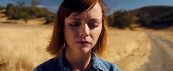 Movie still from “Monstrous” (2022), directed by Chris Sivertson – A person with her eyes closed; Close Up shot, Low angle