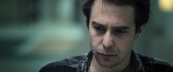 Movie still from “Moon” (2009), directed by Duncan Jones – A man's face with a blurry background; Close Up shot, Over the shoulder angle