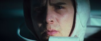 Movie still from “Moon” (2009), directed by Duncan Jones – A man's face looking at a piece of paper; Close Up shot, Low angle