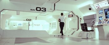 Movie still from “Moon” (2009), directed by Duncan Jones – A man walking down a ramp in a building; Wide shot, High angle