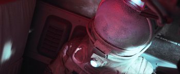 Movie still from “Moon” (2009), directed by Duncan Jones – A person's face in a kitchen; Close Up shot, Overhead angle