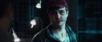 Movie still from “Moon” (2009), directed by Duncan Jones – A person wearing a hat; Close Up shot, Over the shoulder angle
