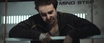 Movie still from “Moon” (2009), directed by Duncan Jones – A man holding a doughnut in his hand; Close Up shot, High angle