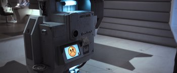 Movie still from “Moon” (2009), directed by Duncan Jones – A video camera with a sad face on the screen; Close Up shot, Overhead angle