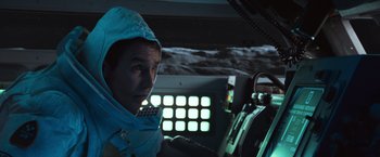 Movie still from “Moon” (2009), directed by Duncan Jones – A man in a space suit sitting in the cockpit of a space ship; Close Up shot, Low angle