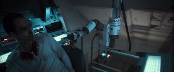 Movie still from “Moon” (2009), directed by Duncan Jones – A view of the inside of an airplane with a view of the cockpit; Medium shot, Overhead angle
