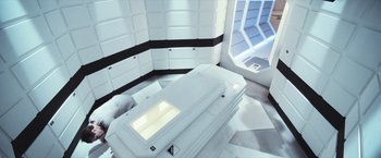 Movie still from “Moon” (2009), directed by Duncan Jones – A room with a bed and a window in it; Wide shot, Overhead angle