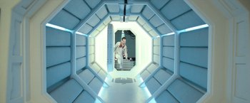 Movie still from “Moon” (2009), directed by Duncan Jones – A man standing inside of an empty space ship; Wide shot, Overhead angle