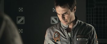 Movie still from “Moon” (2009), directed by Duncan Jones – A man in a gray jacket is looking down at his face; Close Up shot, Over the shoulder angle