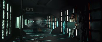 Movie still from “Moon” (2009), directed by Duncan Jones – A person is standing in a dark room with lights on; Wide shot, High angle