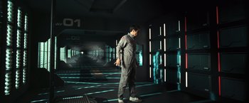Movie still from “Moon” (2009), directed by Duncan Jones – A man standing in a room with lights on the walls; Wide shot, Low angle