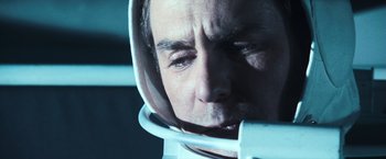 Movie still from “Moon” (2009), directed by Duncan Jones – A person wearing a space helmet; Close Up shot, High angle