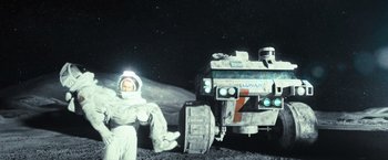 Movie still from “Moon” (2009), directed by Duncan Jones – An image of a man sitting on the moon next to a truck; Wide shot, Low angle