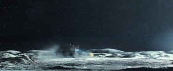Movie still from “Moon” (2009), directed by Duncan Jones – A truck driving on a road in the middle of the night; Extreme Wide shot, Low angle