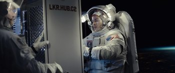 Movie still from “Moonfall” (2022), directed by Roland Emmerich – A man in a spacesuit is looking at a computer screen; Medium shot, Low angle