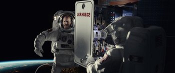 Movie still from “Moonfall” (2022), directed by Roland Emmerich – Two people in spacesuits are looking into a mirror; Wide shot, Low angle