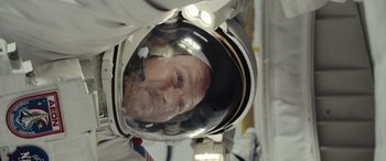 Movie still from “Moonfall” (2022), directed by Roland Emmerich – A man in a space suit and a helmet; Close Up shot, Overhead angle