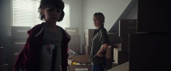 Movie still from “Moonfall” (2022), directed by Roland Emmerich – A woman standing in front of boxes in a room; Medium shot, Over the shoulder angle