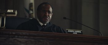 Movie still from “Moonfall” (2022), directed by Roland Emmerich – A man wearing a black robe and a white tie; Close Up shot, Low angle