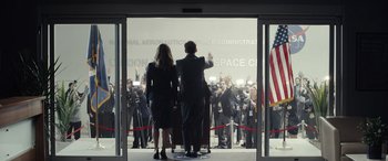 Movie still from “Moonfall” (2022), directed by Roland Emmerich – A man and a woman wave at a crowd; Wide shot, Low angle