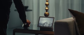 Movie still from “Moonfall” (2022), directed by Roland Emmerich – A tablet computer sitting on top of a glass table; Extreme Close Up shot, Over the shoulder angle