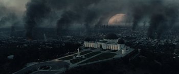 Movie still from “Moonfall” (2022), directed by Roland Emmerich – An aerial view of a city with a moon in the background; Extreme Wide shot, High angle