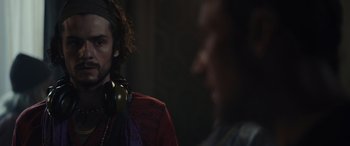 Movie still from “Moonfall” (2022), directed by Roland Emmerich – A man with headphones on and another man in the background; Close Up shot, Over the shoulder angle