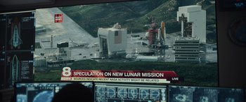 Movie still from “Moonfall” (2022), directed by Roland Emmerich – A television screen showing a news story about a space station; Extreme Wide shot, High angle