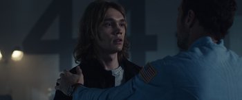 Movie still from “Moonfall” (2022), directed by Roland Emmerich – A man with long brown hair is holding another man's arm; Close Up shot, Over the shoulder angle