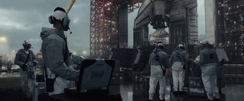 Movie still from “Moonfall” (2022), directed by Roland Emmerich – A group of people standing in front of an industrial building; Extreme Wide shot, Low angle