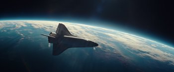 Movie still from “Moonfall” (2022), directed by Roland Emmerich – An image of an airplane flying in the sky above the earth; Extreme Wide shot, Overhead angle