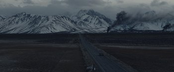 Movie still from “Moonfall” (2022), directed by Roland Emmerich – A truck driving down a road in the middle of a valley; Extreme Wide shot, High angle