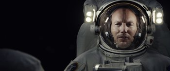 Movie still from “Moonfall” (2022), directed by Roland Emmerich – A man in a spacesuit with a helmet on his head; Close Up shot, Overhead angle