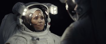Movie still from “Moonfall” (2022), directed by Roland Emmerich – A woman in a spacesuit looking into a mirror; Close Up shot, Over the shoulder angle