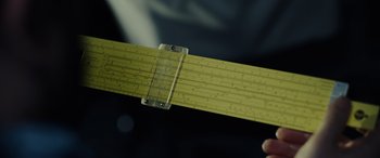 Movie still from “Moonfall” (2022), directed by Roland Emmerich – A ruler that is being held by a person; Extreme Close Up shot, High angle