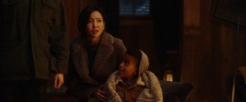 Movie still from “Moonfall” (2022), directed by Roland Emmerich – A woman sitting next to a child in a room; Medium shot, Low angle