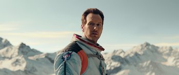 Movie still from “Moonfall” (2022), directed by Roland Emmerich – A man in a space suit standing in front of a mountain; Close Up shot, Low angle