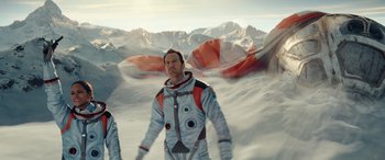 Movie still from “Moonfall” (2022), directed by Roland Emmerich – A man in a spacesuit standing in the snow; Wide shot, Low angle