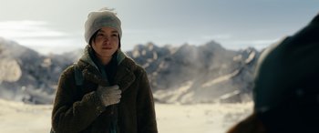 Movie still from “Moonfall” (2022), directed by Roland Emmerich – A woman in a brown coat and a gray hat; Medium shot, Over the shoulder angle