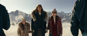 Movie still from “Moonfall” (2022), directed by Roland Emmerich – A group of people standing in the snow holding hands; Medium shot, Low angle