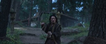 Movie still from “Mortal Kombat” (2021), directed by Simon McQuoid – A man holding a sword in his hands; Medium shot, Low angle