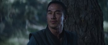 Movie still from “Mortal Kombat” (2021), directed by Simon McQuoid – A person wearing a robe near a tree; Close Up shot, Low angle