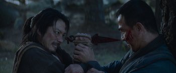 Movie still from “Mortal Kombat” (2021), directed by Simon McQuoid – Two men are fighting with a knife and a rope; Close Up shot, High angle