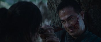 Movie still from “Mortal Kombat” (2021), directed by Simon McQuoid – A man holding a knife near a woman's face; Close Up shot, Over the shoulder angle