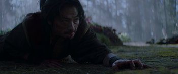 Movie still from “Mortal Kombat” (2021), directed by Simon McQuoid – A man laying on the ground in the rain; Close Up shot, High angle