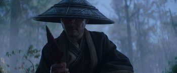 Movie still from “Mortal Kombat” (2021), directed by Simon McQuoid – A man wearing a hat and holding a knife; Close Up shot, Low angle