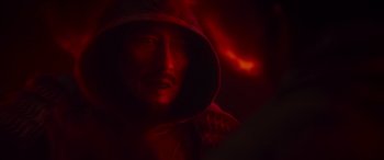 Movie still from “Mortal Kombat” (2021), directed by Simon McQuoid – A man in a hooded jacket is in the dark; Extreme Close Up shot, Over the shoulder angle
